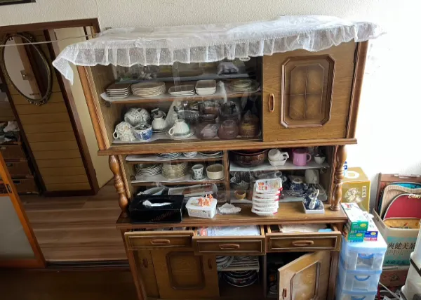 食器棚や生活用品が残る部屋（遺品整理の現場のイメージ）